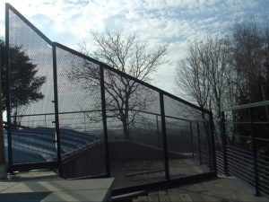 Une clôture métallique avec une piscine en arrière-plan.