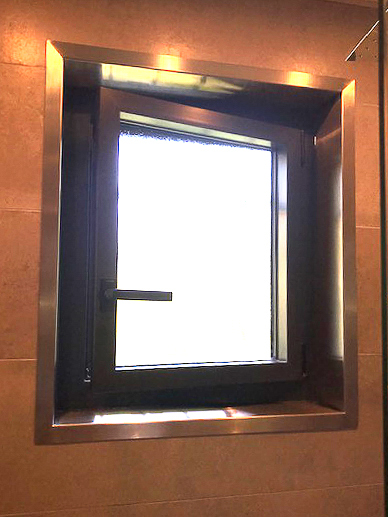 Une fenêtre à cadre métallique dans une salle de bain.