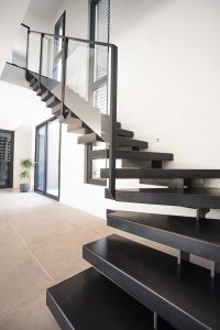 Un escalier noir dans une maison.