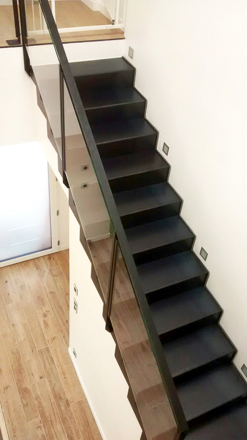 Escalier métallique noir avec rampe en verre, réalisé sur mesure par un artisan métallier de Lyon, expert en fabrication de haute qualité dans le département du Rhône.