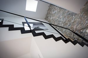 Un escalier dans une maison avec une rampe noire.