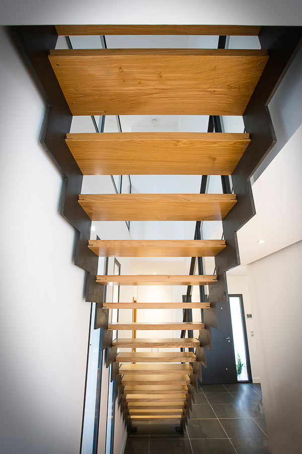 Un escalier métallique sur mesure conçu par un artisan lyonnais du département du Rhône, avec des marches en bois de grande qualité, démontrant son habileté exceptionnelle et son souci du détail dans la préparation de chaque pièce.