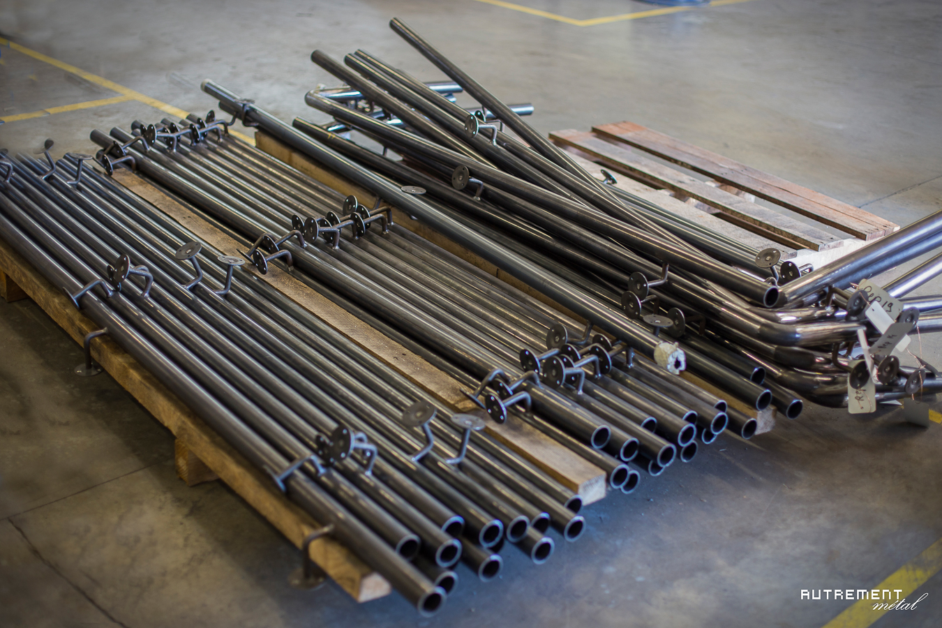 Un tas de tuyaux en acier sur une palette dans un entrepôt.