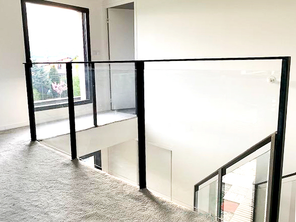 Une rampe d'escalier en métal dans une pièce avec une fenêtre.