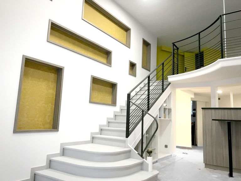 Un escalier dans une maison avec un mur jaune.