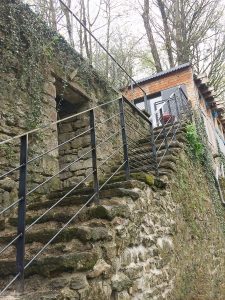 Un escalier menant à une maison dans une zone boisée.