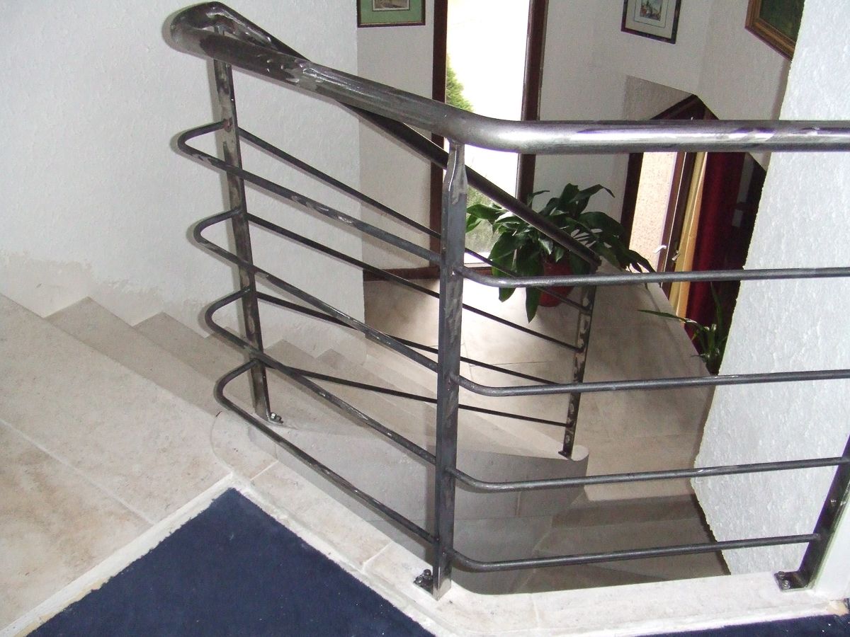 Un escalier avec une rampe en métal.