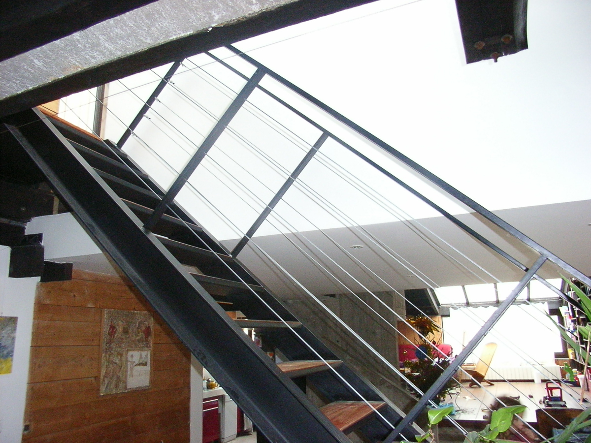 Un escalier avec une rampe en métal.