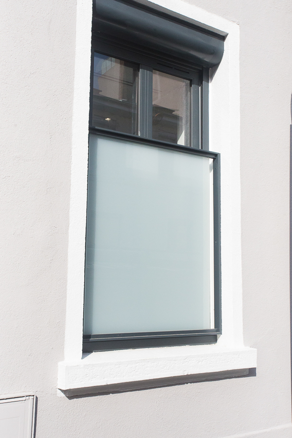 Une fenêtre avec un cadre blanc et un verre dépoli.