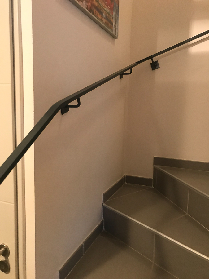 Une rampe d'escalier noire avec une photo dessus.