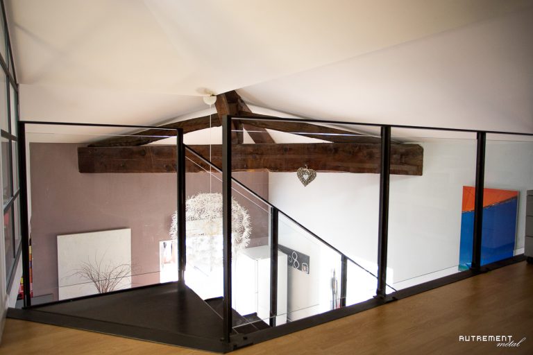 Un escalier en bois dans une maison avec une rampe en verre.
