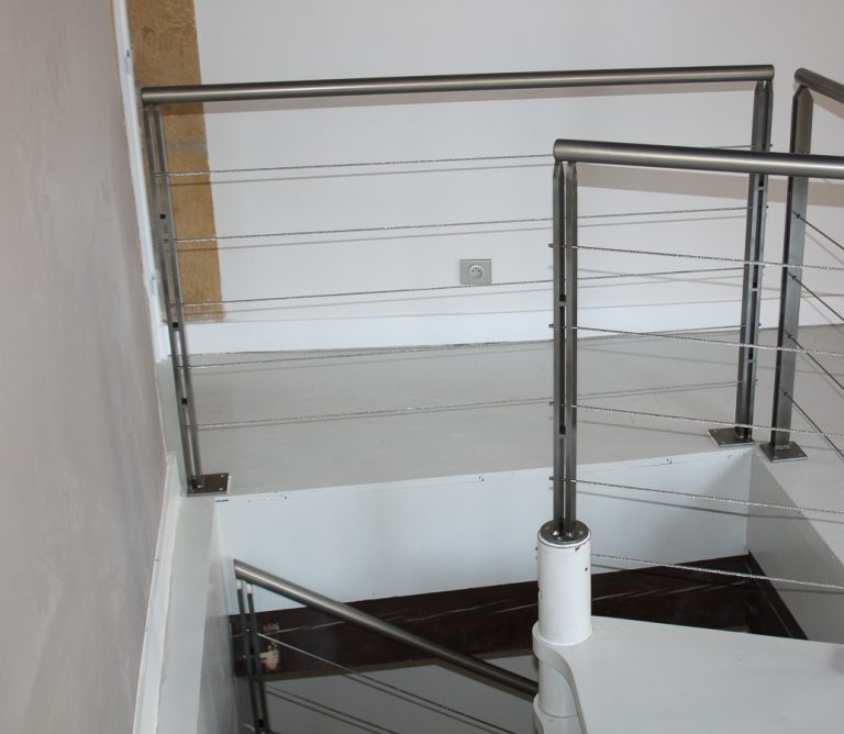 Une rampe métallique sur un escalier.
