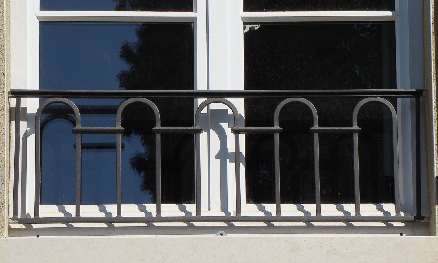Une fenêtre avec une balustrade en métal noir.