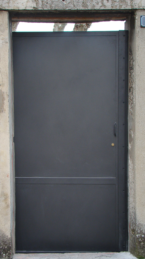 Une porte métallique avec une poignée noire.