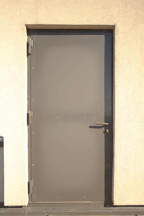 Une porte métallique sur le côté d'un bâtiment.