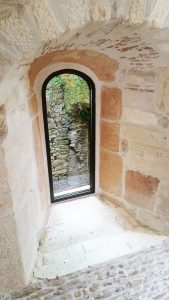 Une fenêtre en arc dans un mur de pierre.