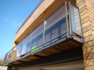 Une balustrade en bois sur un balcon en métal.