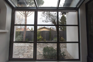 Une porte vitrée à cadre métallique dans une maison.