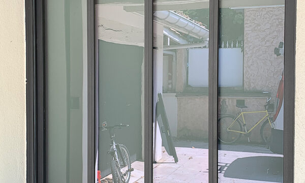 "Baie vitrée sur mesure en métal, installée à Lyon."