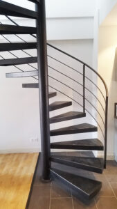 Un escalier en colimaçon en métal dans un salon.
