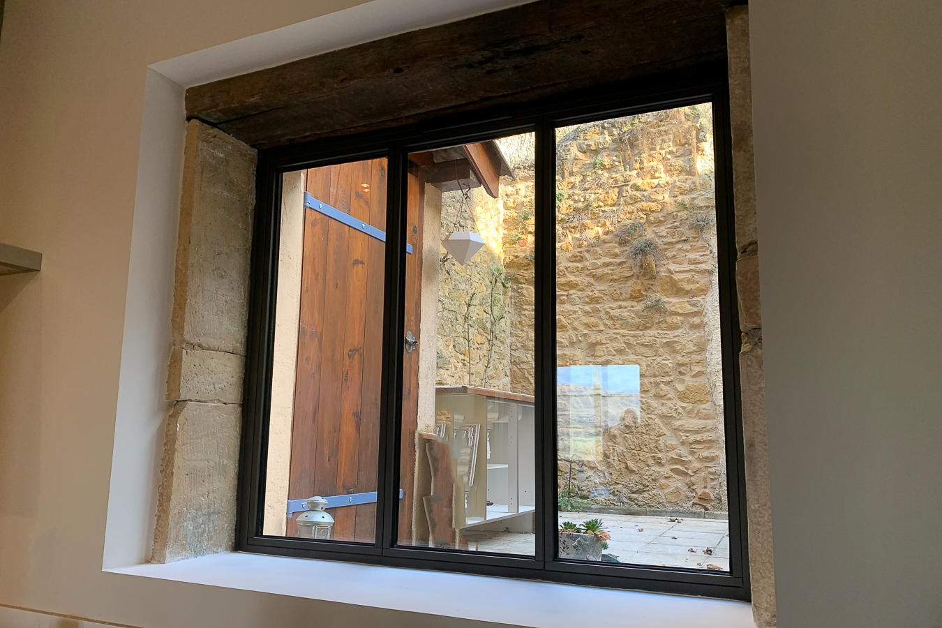 Une fenêtre dans une pièce avec un mur de pierre en métal.