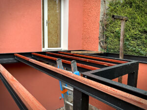 Une échelle métallique est utilisée pour construire le toit d’une maison.