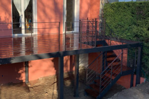 Un balcon avec une balustrade métallique et des escaliers.