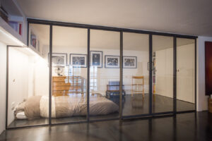 Une chambre avec un lit métallique et une table de chevet.