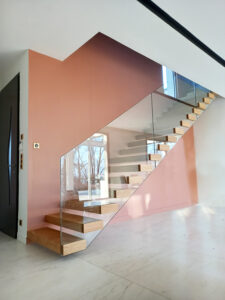 Un escalier dans une maison avec garde-corps en verre.