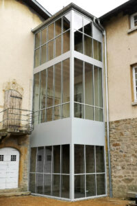 Un bâtiment avec un mur de verre et une porte.