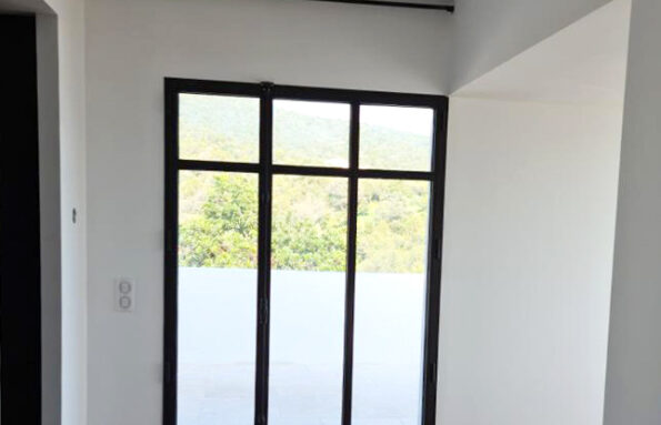 Une pièce avec du parquet et une porte coulissante en verre.