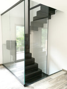 Un escalier métallique avec des cloisons en verre dans une maison.