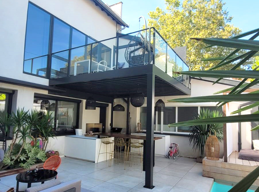 Une maison à Lyon avec une belle terrasse en métal sur pilotis.