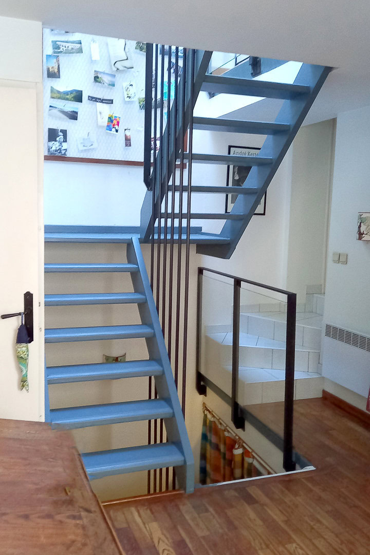 Un élégant escalier bleu doté de garde-corps contemporains.