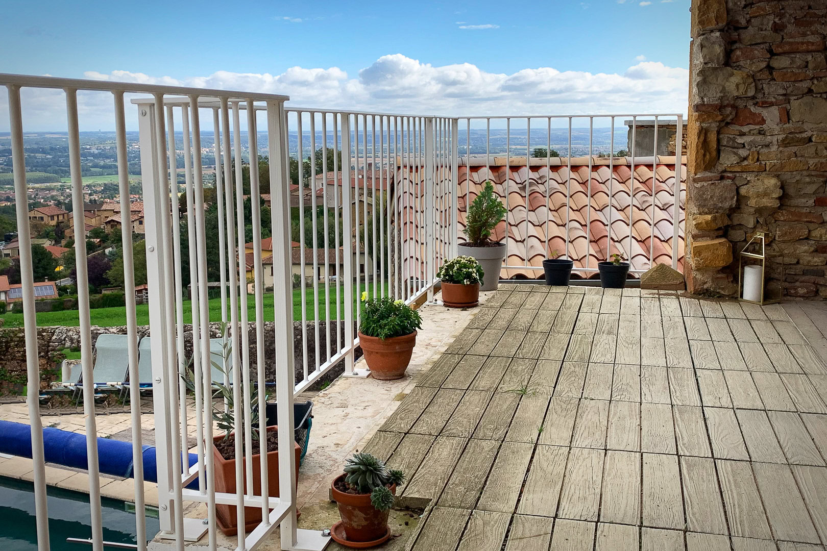 Un balcon fleuri avec un garde-corps contemporain en métal peint.