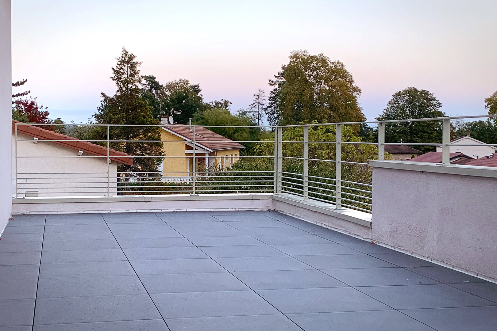 Terrasse sur le toit avec garde-corps contemporain dans un quartier résidentiel de Lyon.