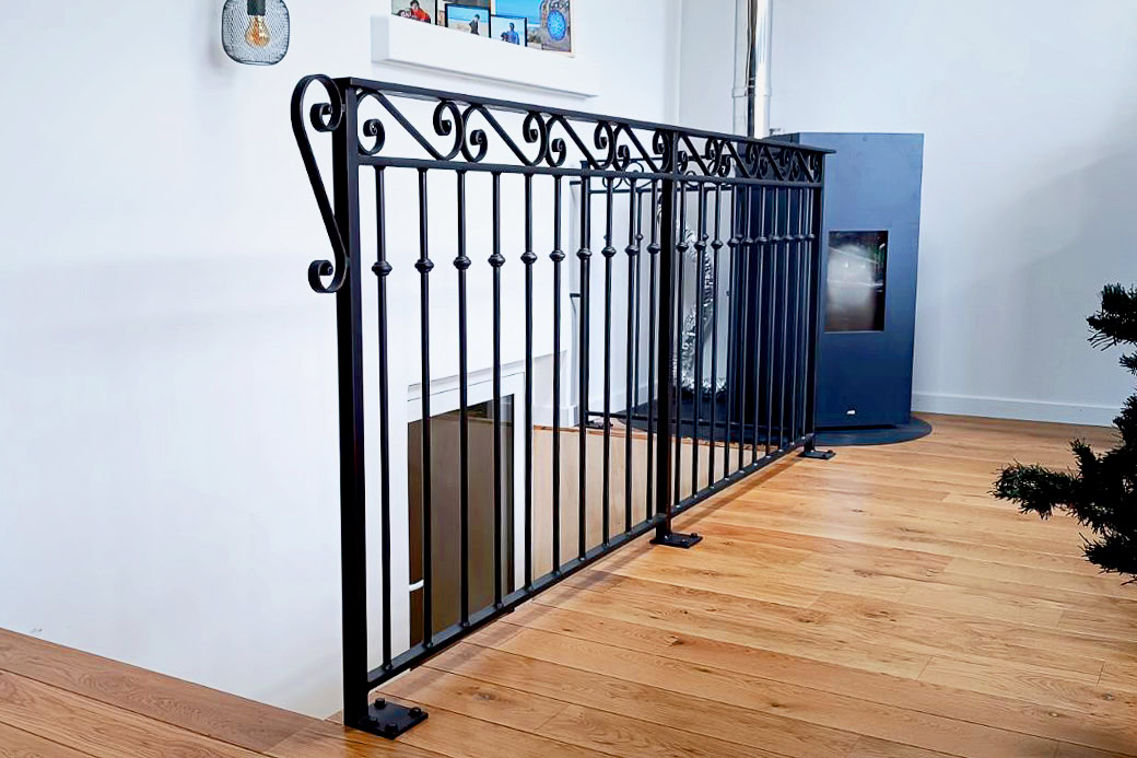 Une rampe d'escalier traditionnelle en métal noir pour laisser passer la lumière avec style dans cette maison lyonnaise ancienne.