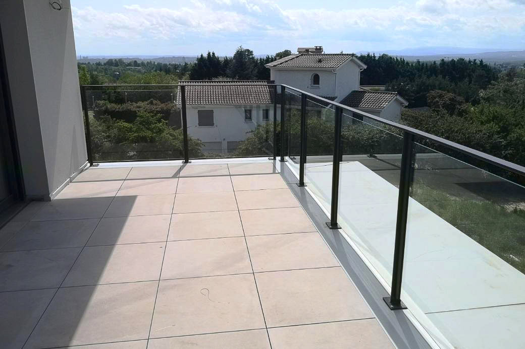Garde-corps en métal et verre réalisé par un métallier près de Lyon, posé sur une terrasse carrelée.