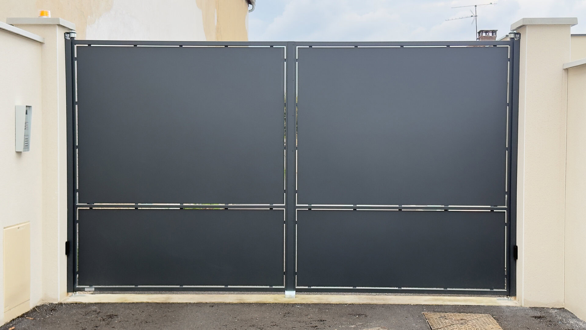 Portail battant double en métal gris mat, à panneaux pleins, réalisé et posé par un métallier près de Lyon.