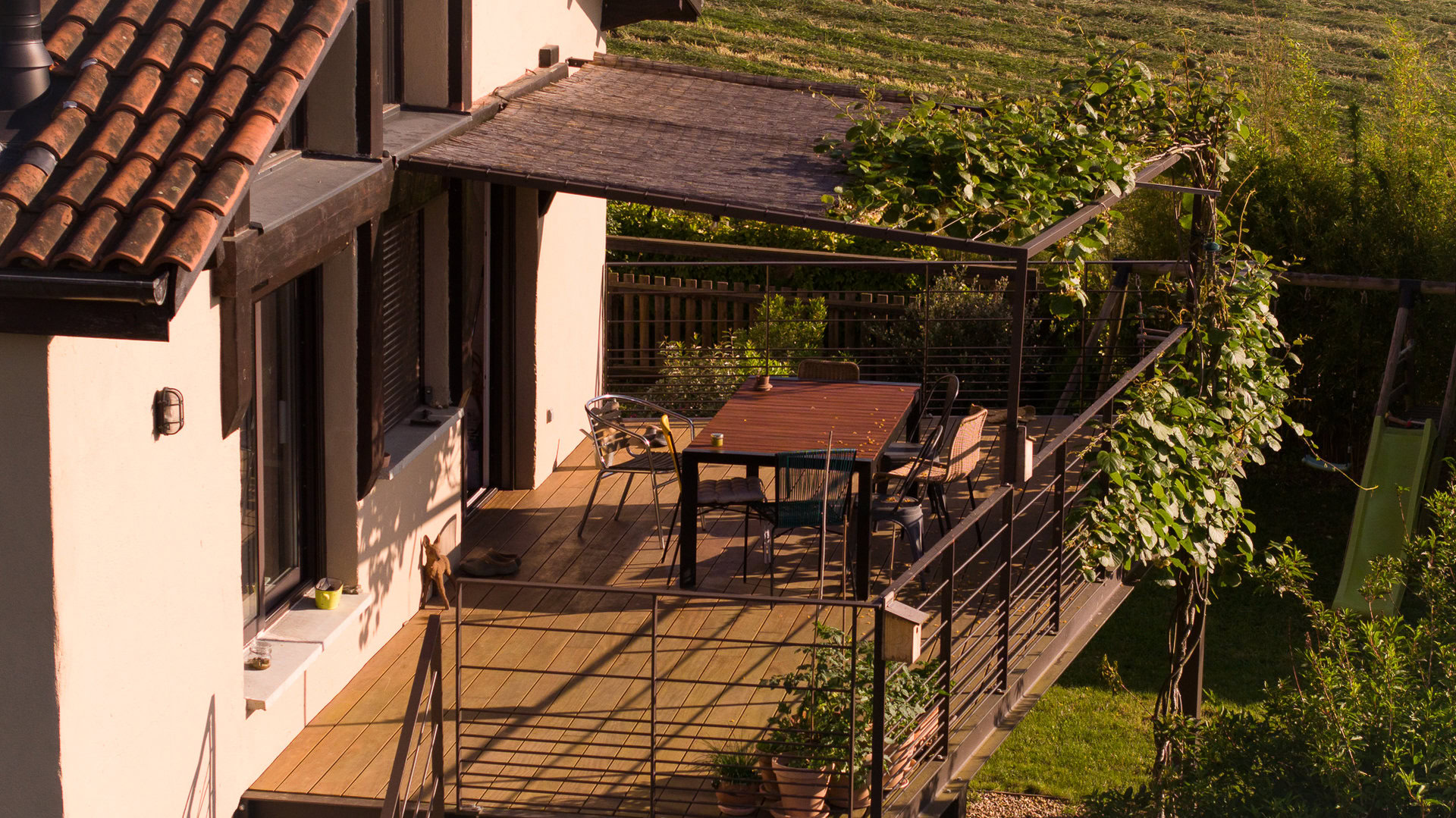 Un balcon-terrasse métallique avec rambarde surplombe un jardin, réalisé par une entreprise de métallerie près de Lyon.