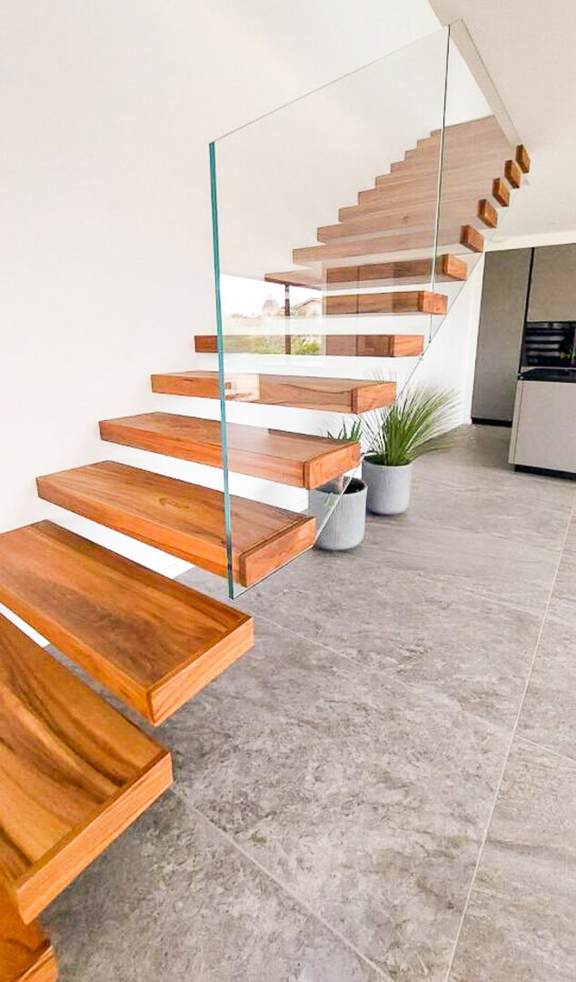 Un escalier flottant moderne en m&eacute;tal avec un garde-corps en verre, con&ccedil;u et install&eacute; par un m&eacute;tallier pr&egrave;s de Lyon dans le Rh&ocirc;ne.